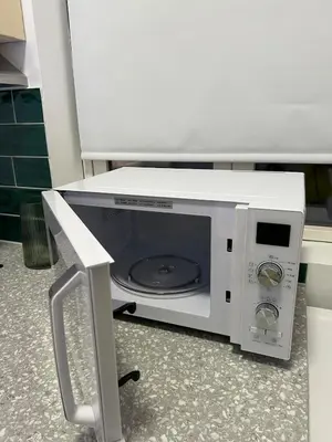 a microwave oven with its door open on the floor at Cozy and modern studio house in Trondheim
