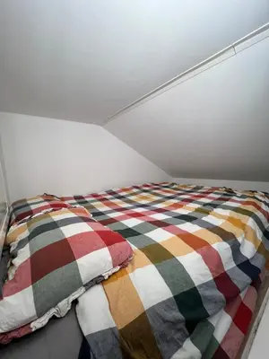 a bed with a colorful blanket on top of it at Cozy and modern studio house in Trondheim