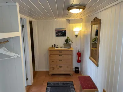 a hallway with a wooden dresser in a room at Sokkelleilighet med 3 soverom in Molde