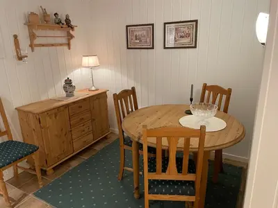 a dining room with a wooden table and chairs at Sokkelleilighet med 3 soverom in Molde