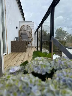 a porch with a wicker chair on a deck at New Modern House by the Sea in Askøy