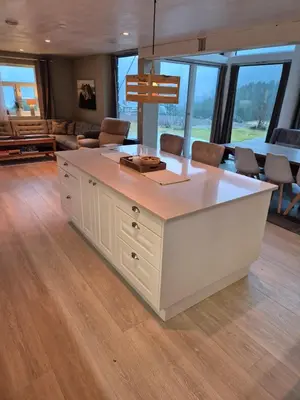a kitchen with a white island in a living room at Idyllic house with views - close to nature in Nydalen