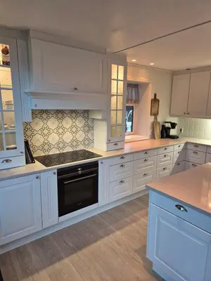 a kitchen with white cabinets and a black dishwasher at Idyllic house with views - close to nature in Nydalen