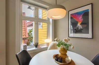 a dining room with a table and a window at Cosy flat in historical lane in Bergen