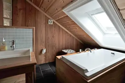a bathroom with a large white tub and a skylight at Family Cabin For Many In The High Mountains in Hovet