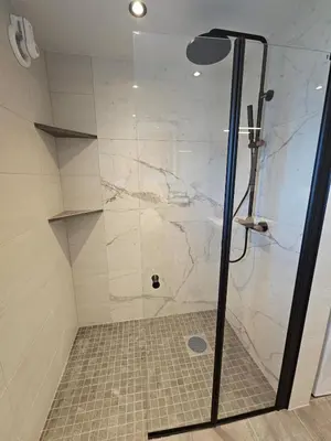a shower with a glass door in a bathroom at Newly renovated apartment in beautiful Haramsøy in Ålesund