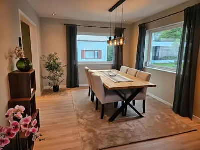 a dining room with a wooden table and chairs at Newly renovated apartment in beautiful Haramsøy in Ålesund