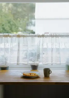 a table with a plate of oranges and a coffee cup at Newly renovated apartment in beautiful Haramsøy in Ålesund