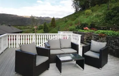 a patio with two chairs and a coffee table at Cozy Apartment In Fitjar in Fitjar