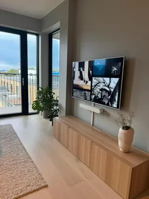 a living room with a large flat screen tv on the wall at LADE - leilighet i Ringve Pluss in Trondheim