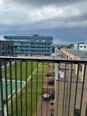a balcony with a view of a building and a parking lot at LADE - leilighet i Ringve Pluss in Trondheim