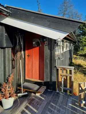 a house with a red door on a deck at Traditional Family Cabin Near Rabalen in Bagn