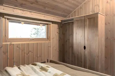 a bedroom with wood paneled walls and a window at Hedda Hedalsfjellet - 3 bedroom cabin with a lovely view in Hedalen