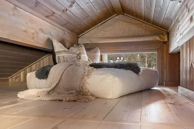 a bedroom with a large white couch on a wooden floor at Hedda Hedalsfjellet - 3 bedroom cabin with a lovely view in Hedalen