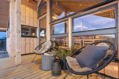 a porch with two wicker chairs on a wooden deck at Hedda Hedalsfjellet - 3 bedroom cabin with a lovely view in Hedalen