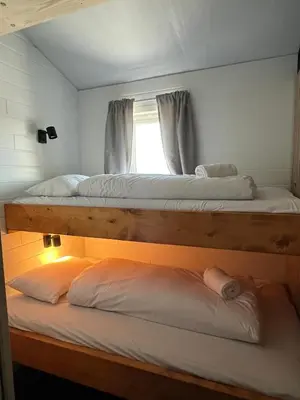 two bunk beds in a room with a window at Mountain Sauna Lodge - Private Sunset Deck in Vossevangen