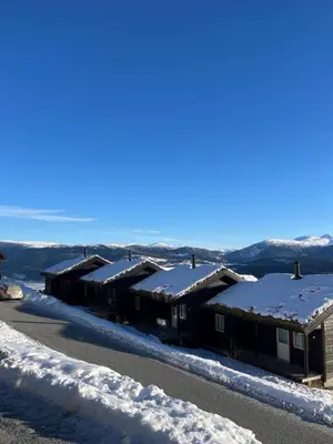 a row of houses covered in snow on a road at Mountain Sauna Lodge - Private Sunset Deck in Vossevangen