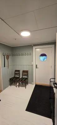 a room with two chairs sitting next to a door at Fjellheimens Svanebu in Tyinkrysset