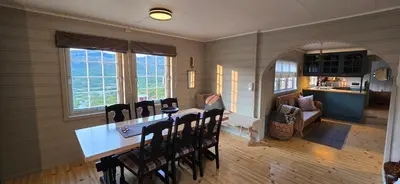 a kitchen and dining room with a table and chairs at Fjellheimens Svanebu in Tyinkrysset