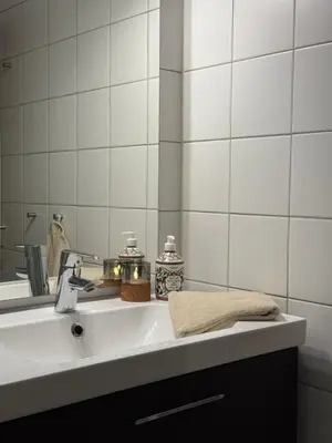 a bathroom sink with a towel and a mirror at Geiloholtet central city apartment in Geilo