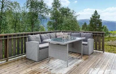 a patio with a couch and a table on a deck at Cozy Home In Hornindal With Sauna in Hornindal