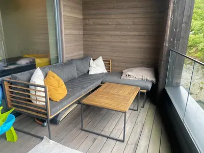 a couch and a table on a porch at Familyhome for 8 people - 4 bedrooms - 10min from Bergen city center in Bergen