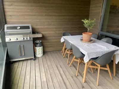 a table and chairs on a patio with a stove at Familyhome for 8 people - 4 bedrooms - 10min from Bergen city center in Bergen