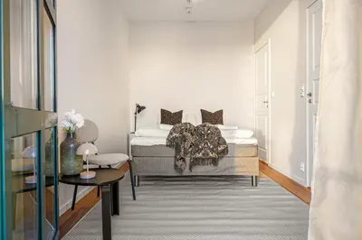 a white bedroom with a bed and a table at Heimby Homes - Seaside Balcony Stay in Bergen