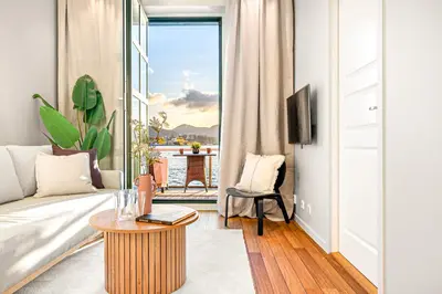 a living room with a couch and a table at Heimby Homes - Seaside Balcony Stay in Bergen