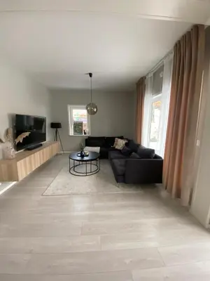 a living room with a black couch and a table at Modern apartment in beautiful Lofoten in Lii