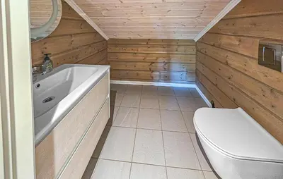 a bathroom with a toilet and a tub and a sink at Awesome Home In Vinje With Sauna in Trovatn