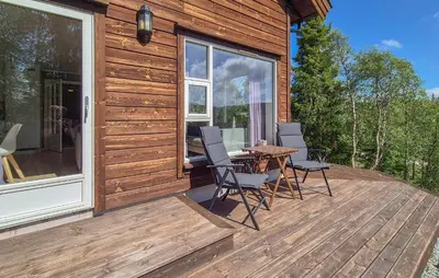 a wooden deck with a table and chairs on it at 4 Bedroom Gorgeous Home In Edland in Vågsli