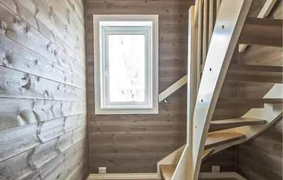 a wooden staircase in a house with a window at 4 Bedroom Gorgeous Home In Edland in Vågsli