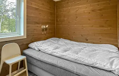 a small bedroom with a bed and a chair at 4 Bedroom Gorgeous Home In Edland in Vågsli