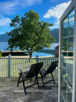 two chairs on a deck with a view of the water at Renovated 1918 House By The Sea In Sandeid in Sandeid