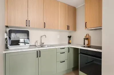 a kitchen with white cabinets and a microwave at City Apartment I Short Walk to Sights in Bergen