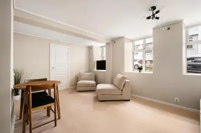 a living room with a table and a chair at City Apartment I Short Walk to Sights in Bergen