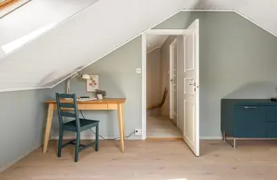 a room with a desk and a chair in a attic at Sentrumsnær bolig in Lii