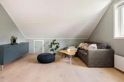 a living room with a couch and a table at Sentrumsnær bolig in Lii