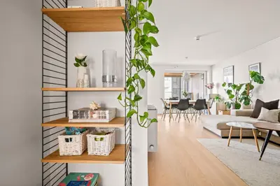 a living room with white walls and wooden shelves at Modern & Spacious City Apartment in Bergen