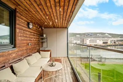 a room with a large window with a couch and a table at Modern & Spacious City Apartment in Bergen