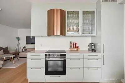 a kitchen with white cabinets and a stove top oven at Modern & Spacious City Apartment in Bergen