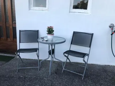 two chairs and a table with a potted plant on it at Two floors house with 3 bed rooms and room for 8 persons in Ålesund
