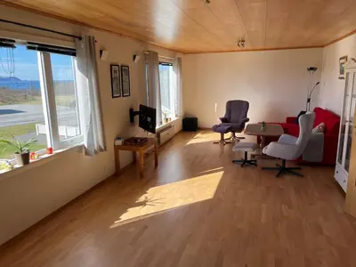 a living room with a table and chairs and a couch at Two floors house with 3 bed rooms and room for 8 persons in Ålesund