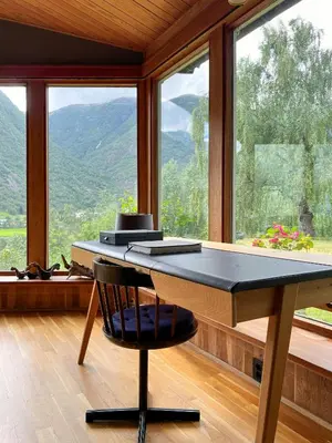 a table with a chair in front of a window at Historic Cabin By Lærdal River in Tønjum