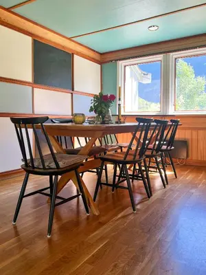 a dining room with a wooden table and chairs at Historic Cabin By Lærdal River in Tønjum