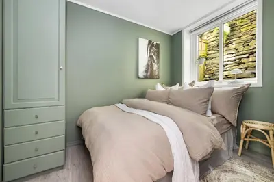 a bedroom with a large bed with a window at Charming Apartment, Walk to Everything in Bergen in Lii
