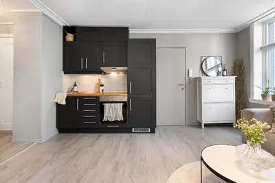 a kitchen with black cabinets and a table at Charming Apartment, Walk to Everything in Bergen in Lii