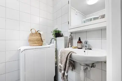 a white bathroom with a sink and a washing machine at Charming Apartment, Walk to Everything in Bergen in Lii