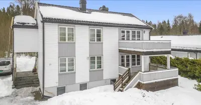 a white house with snow on the ground at Family & Friends Space in Råholt in Lii